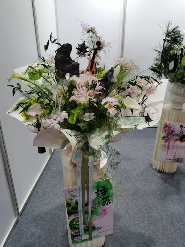 零交会静态花艺展区的中式花艺作品，以太湖石、琵琶、亭榭为元素