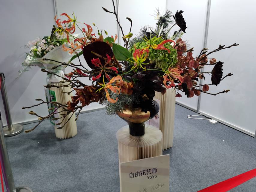 自由花艺师 YoYo 在零交会展示的花艺作品，火焰百合配深色枝材
